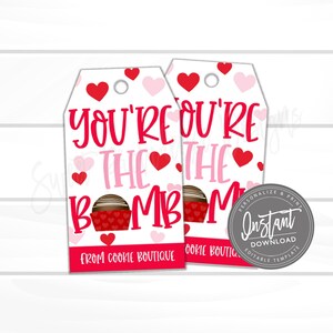 May include: Two Valentine's Day gift tags with a white background, red and pink hearts, and the text "YOU'RE THE BOMB". Each tag features a chocolate treat graphic and the words "FROM COOKIE BOUTIQUE". A circular "Instant Download" graphic is on the right.