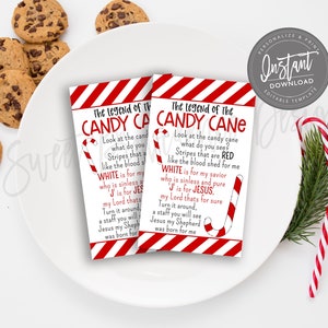 May include: Two rectangular cards with the text "The Legend of the Candy Cane" in red and white, featuring a candy cane illustration. The cards are on a white plate with chocolate chip cookies and candy canes.
