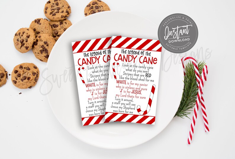 May include: Two rectangular cards with the text "The Legend of the Candy Cane" in red and white, featuring a candy cane illustration. The cards are on a white plate with chocolate chip cookies and candy canes.