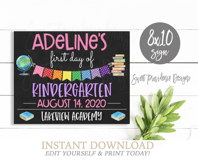 May include: A printable 8x10 inch sign with a chalkboard background. The sign says "Adeline's first day of Kindergarten - August 14, 2020 - Lakeview Academy". The sign is decorated with a globe, books, and a rainbow banner.