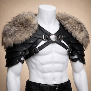 Puede incluir: Armadura de hombro de cuero negro con cuello de piel. La armadura presenta múltiples capas, remaches metálicos y correas ajustables con hebillas. El cuello de piel es una mezcla de marrón, gris y blanco.