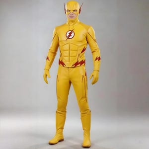 Pode incluir: Uma pessoa em um traje de super-herói amarelo. O traje apresenta um raio no peito e detalhes de raios vermelhos. A roupa inclui uma máscara, luvas, botas e um traje justo.