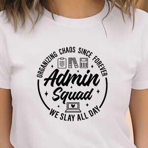 May include: White t-shirt with a black graphic that reads "Organizing Chaos Since Forever Admin Squad We Slay All Day." The design includes icons of a file, books, a calculator, and a laptop with a heart.