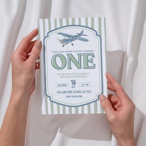 May include: A birthday invitation with a vintage airplane illustration. The invitation features the text "TIME FLIES WHEN YOU'RE TURNING ONE" and details for a first birthday celebration, including the date, time, and location.