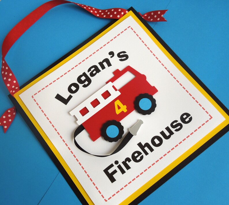 May include: A red and white fire truck with a black hose and a yellow number 4 on the side. The truck is on a white background with black text that says "Logan's Firehouse".