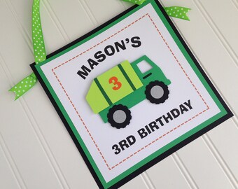 May include: Green and black birthday banner with a green and yellow dump truck with the number 3 on the side. The banner says "MASON'S 3RD BIRTHDAY".