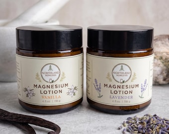 May include: Two amber glass jars with black lids containing Northland Remedies Magnesium Lotion. One label reads Vanilla with white flower illustrations, the other reads Lavender with purple flower sprigs. Each jar is 4 fl oz or 118 g.