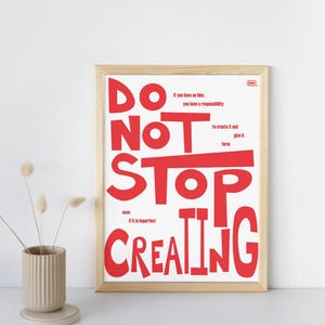 May include: A framed art print with the words "DO NOT STOP CREATING" in large red letters. The print includes additional text: "If you have an idea, you have a responsibility to create it and give it form, even if it is imperfect."