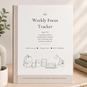 May include: A hardcover weekly focus tracker for ages 11-13, designed to help tweens and parents with homework routines. The cover features the text "Weekly Focus Tracker" and includes line drawings of school supplies. The book is on a wooden surface.