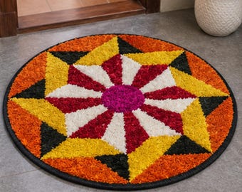 May include: A round rug featuring a vibrant geometric star pattern. The design consists of a central magenta circle surrounded by alternating white and red triangular segments, framed by yellow and orange points and black accents.