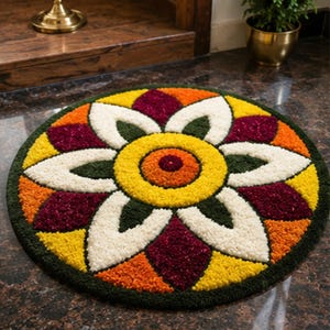 May include: A circular tufted rug featuring a symmetrical floral pattern with a central orange and yellow circle, surrounded by white, dark green, yellow, orange, and deep maroon petal-shaped segments arranged in a repeating geometric design.