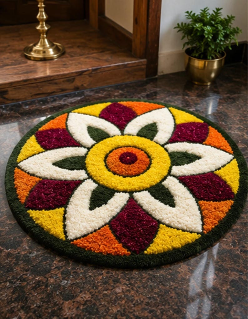May include: A circular tufted rug featuring a symmetrical floral pattern with a central orange and yellow circle, surrounded by white, dark green, yellow, orange, and deep maroon petal-shaped segments arranged in a repeating geometric design.