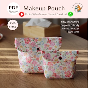 May include: Two floral print makeup pouches in different sizes. The pouches have a flap closure with a dark button. The fabric features a pattern of pink, yellow, and blue flowers on a white background. The image includes text that says "Makeup Pouch" and "PDF Pattern".