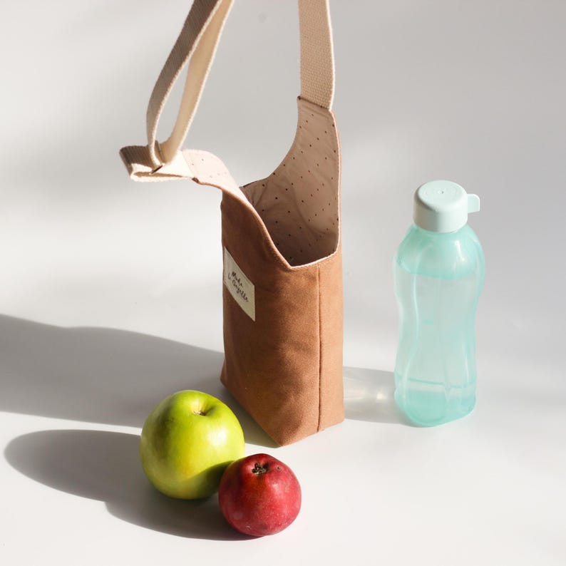 Woman wearing a floral water bottle bag crossbody while wearing athletic gym clothes.