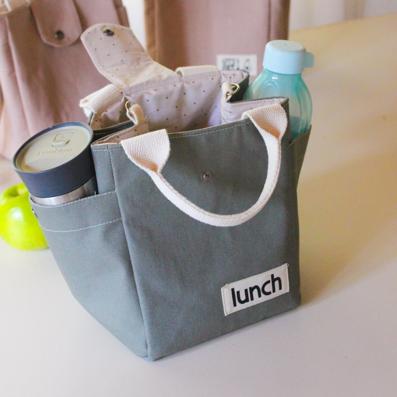 Small tote bag with an adjustable strap, designed as a sustainable alternative to plastic lunch boxes.