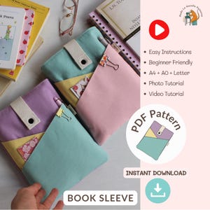 May include: A collection of colorful book sleeves in pastel shades of purple, pink, and teal, with yellow accents. Each sleeve has a pocket and a fabric strap with a button closure. The words "BOOK SLEEVE" are at the bottom.