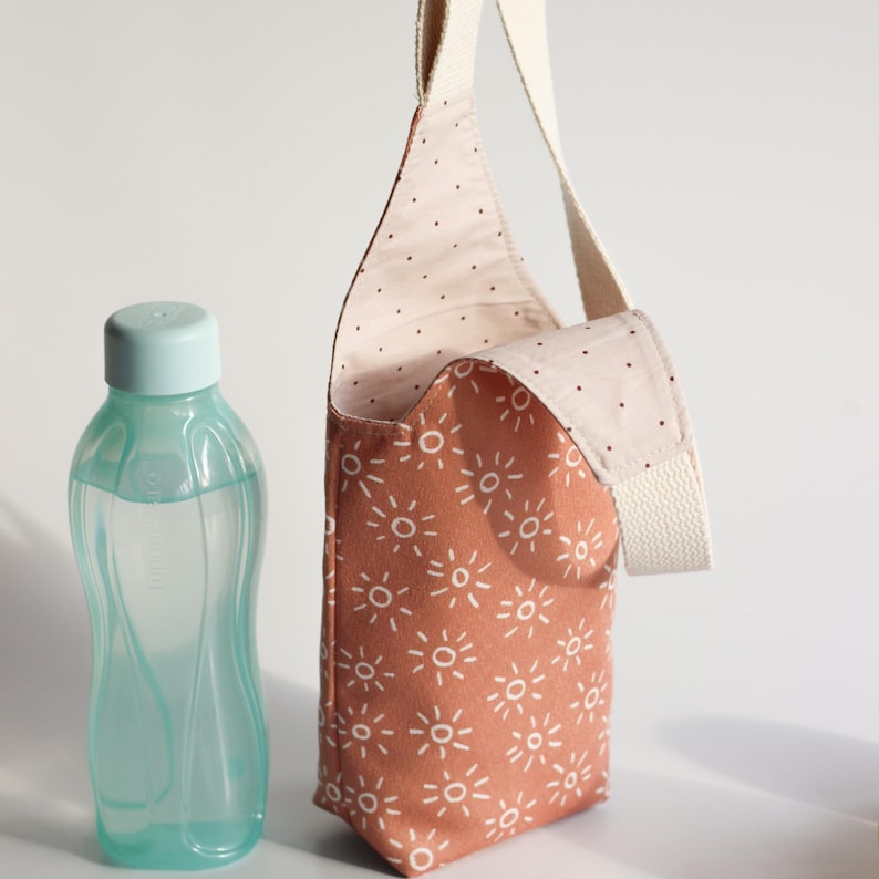 Boho style water bottle sling bag with sunburst pattern in terracotta pink for daily outdoor use.