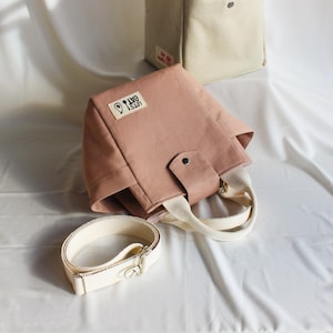 Messenger bag style crossbody lunch box for work or school, made from durable canvas fabric.