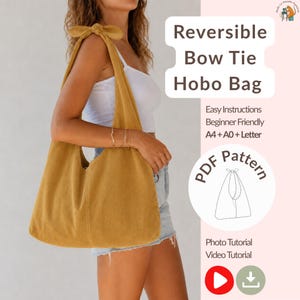 May include: Mustard yellow corduroy hobo bag with a bow tie strap. The bag is held over the shoulder. Text on the image reads "Reversible Bow Tie Hobo Bag" and "PDF Pattern". Additional text includes "Easy Instructions" and "Beginner Friendly".