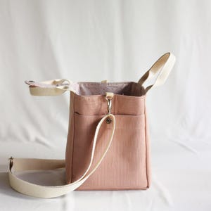 Detailed view of a bottle carrier bag pocket on the side of a handmade canvas lunch tote.