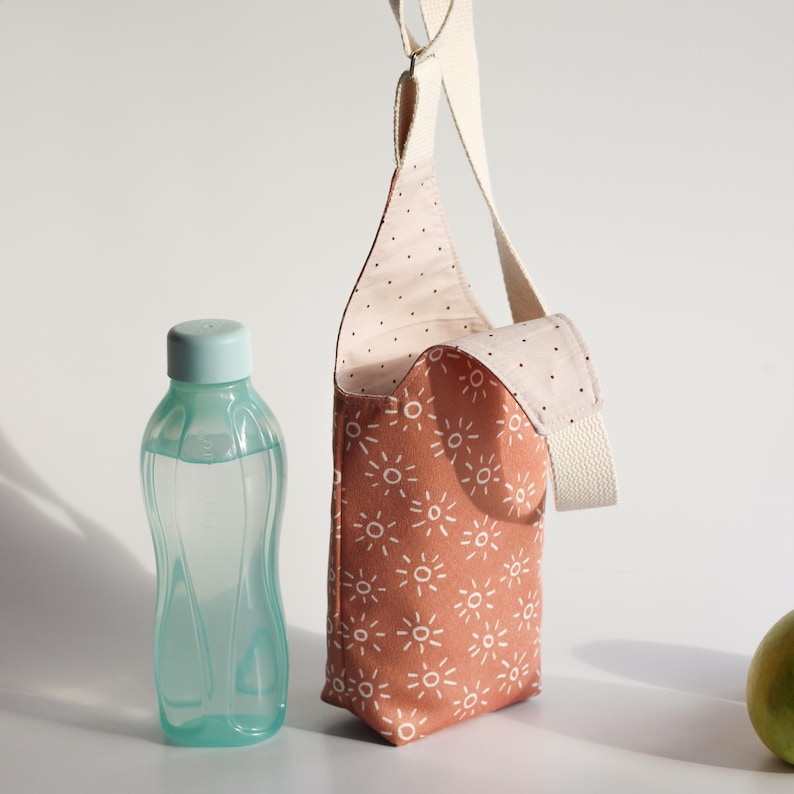 Wine carrier bag styled next to a wine bottle and apples, perfect for picnic or gift ideas.