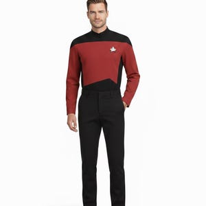 May include: A red and black Star Trek uniform with a Starfleet insignia. The long-sleeved top has a black collar and shoulder yoke, paired with black trousers and shoes. The uniform is a costume.