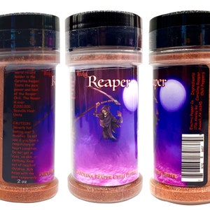 Puede incluir: Un frasco de 57 gramos de hojuelas de chile Carolina Reaper. El frasco tiene una tapa negra y una etiqueta morada y negra con un gr&aacute;fico de calavera y huesos cruzados. La etiqueta dice "Wicked Reaper" y "Carolina Reaper Chili Peppers". La parte posterior del frasco tiene un c&oacute;digo de barras y el texto "Electric Pepper Co. Ingredients: Carolina Reaper Chili Peppers 1716 Akeley Rd Russell, PA 16345"