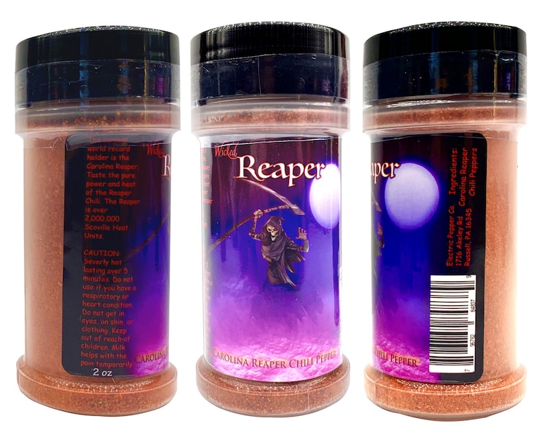 Puede incluir: Un frasco de 57 gramos de hojuelas de chile Carolina Reaper. El frasco tiene una tapa negra y una etiqueta morada y negra con un gr&aacute;fico de calavera y huesos cruzados. La etiqueta dice "Wicked Reaper" y "Carolina Reaper Chili Peppers". La parte posterior del frasco tiene un c&oacute;digo de barras y el texto "Electric Pepper Co. Ingredients: Carolina Reaper Chili Peppers 1716 Akeley Rd Russell, PA 16345"