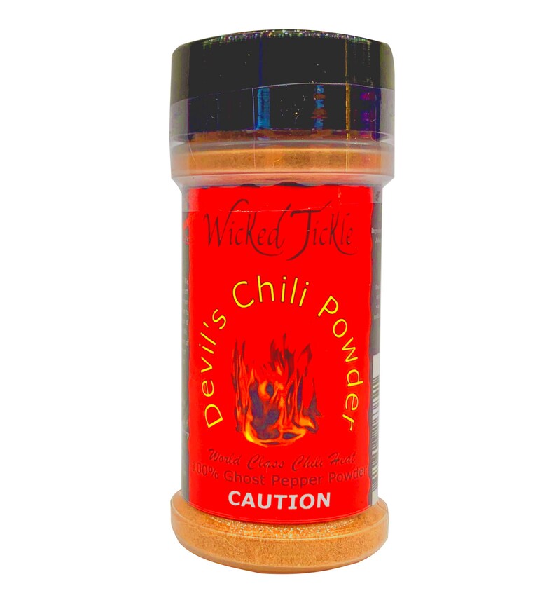 Puede incluir: Un tarro de especias rojo y negro con la etiqueta "Wicked Tickle Devil's Chili Powder" y una etiqueta de advertencia que dice "CAUTION".