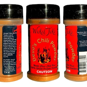 Puede incluir: Tres frascos de 1,5 onzas de Wicked Tickle Devil's Chili Powder, un polvo de chile de fantasma. Los frascos son rojos con tapas negras y una etiqueta negra y blanca con las palabras "Wicked Tickle Devil's Chili Powder" y "World Class Chili Heat 100% Ghost Pepper Powder". La etiqueta tambi&eacute;n incluye una advertencia de precauci&oacute;n.