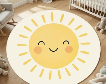 May include: A round, cream-colored rug featuring a smiling sun design. The sun has a yellow center with a smiling face, and yellow rays extend outward. The rug is suitable for a nursery or playroom.