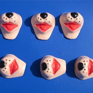 May include: Six pink plastic animal noses with black eyes and red lips. The noses are designed to be used as part of a costume or craft project.