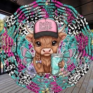 May include: A whimsical wind spinner featuring a cartoon Highland cow wearing a pink cap with the text "Salty Heifer". The cow has butterfly wings and holds a teal tumbler. The background has a colorful, layered design with cow print and floral accents.