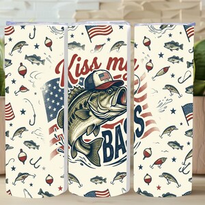 May include: A stainless steel tumbler with a fishing theme. The design features a large bass wearing a hat with the American flag, the text "Kiss my Bass", and a pattern of fish, hooks, and flags.