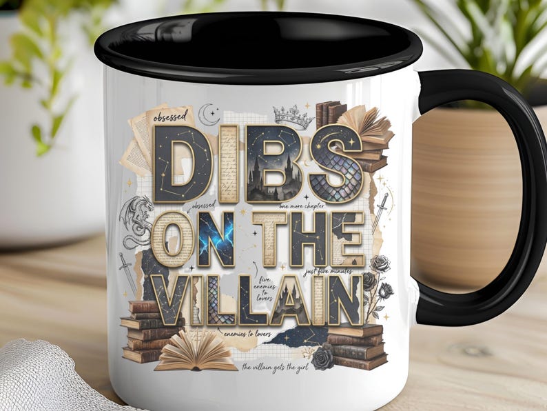 May include: White ceramic mug with a black interior and handle, featuring the text "DIBS ON THE VILLAIN" in a layered design with book and fantasy elements. The mug has a glossy finish and is suitable for hot or cold beverages.