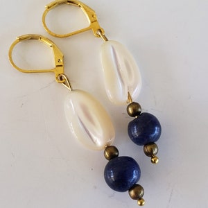 May include: Gold earrings with white oval beads and dark blue round beads.