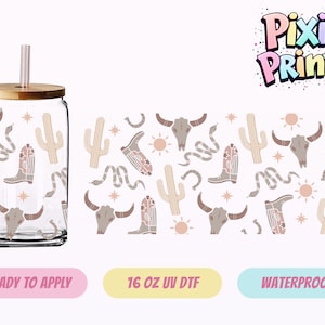 Op de afbeelding: Een doorzichtige glazen beker met een houten deksel en een roze rietje. De beker heeft een herhalend patroon van cactussen, cowboylaarzen, schedels van stieren en slangen. Het ontwerp is in tinten beige en bruin.