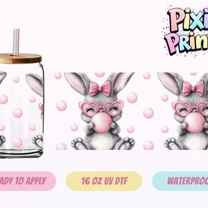 May include: A clear glass tumbler with a bamboo lid and pink straw. The tumbler features a repeating pattern of a gray bunny wearing heart-shaped glasses and blowing a pink bubble. Pink bubbles are scattered throughout the design.