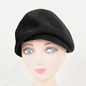 May include: A black felt beret with a slightly rounded crown and a folded brim.