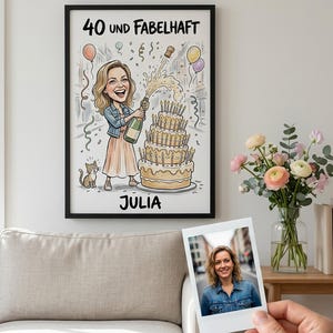 Op de afbeelding: Een ingelijste kunstdruk met een cartoonillustratie van een persoon die een champagnefles ontkurkt naast een verjaardagstaart met meerdere lagen en een kleine kat. De tekst luidt 40 UND FABELHAFT en JULIA.