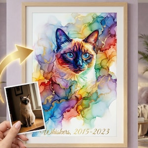 Può includere: Stampa incorniciata ad acquerello di un gatto siamese con occhi blu, su uno sfondo vibrante e colorato. L'opera d'arte include accenti dorati e il testo "Whiskers, 2015-2023". È presente anche una foto più piccola del gatto.