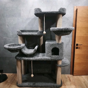 May include: A grey multi-level cat tree with multiple platforms, a hideaway cubby, and scratching posts. The cat tree has a plush, carpet-like texture and includes dangling toys. The posts are wrapped in natural sisal rope.