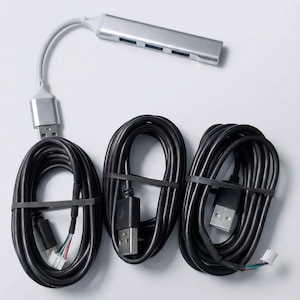 May include: A silver USB hub with four ports and a grey cable, connected to three black USB cables bundled with black rubber bands. The cables have USB connectors on each end.