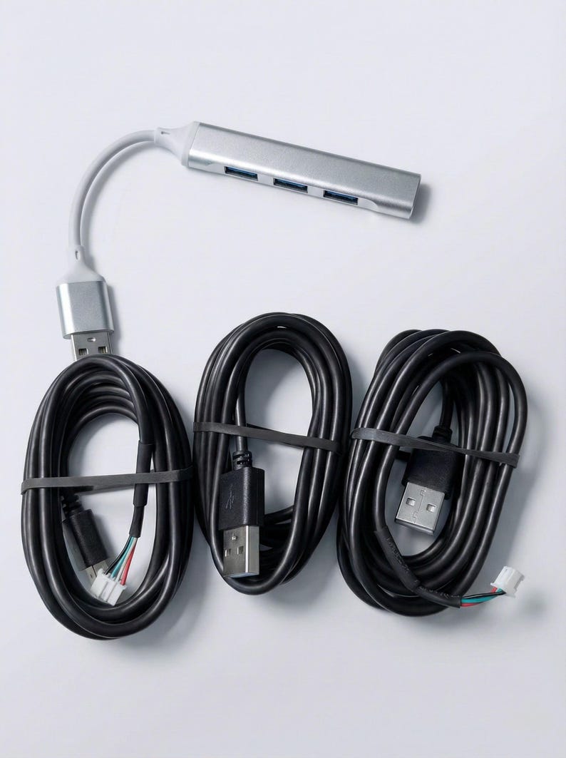 May include: A silver USB hub with four ports and a grey cable, connected to three black USB cables bundled with black rubber bands. The cables have USB connectors on each end.