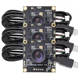 May include: Three black circuit boards with attached lenses, cables, and USB connectors. The boards have gold-coloured mounting holes and the text "HBVCAM-W20217 V22". The cables are black.