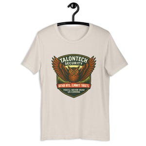 フクロウのグラフィックTシャツ｜面白い野生動物バッジTシャツ｜タロンテックセキュリティ