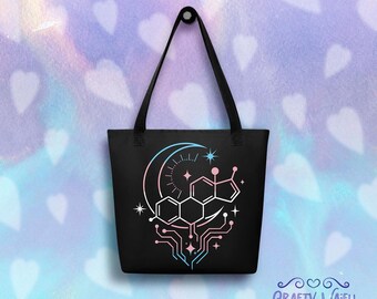 Puede incluir: Bolso tote negro con un diseño gráfico que presenta una luna creciente, una estructura molecular y elementos de placa de circuito en rosa y azul. El bolso tiene asas negras largas y el texto "Crafty Waifu".