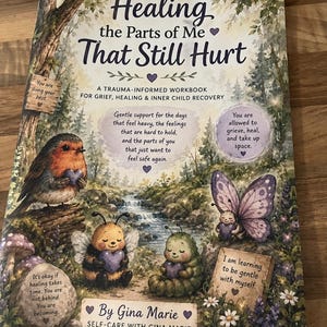 May include: A softcover workbook titled Healing the Parts of Me That Still Hurt by Gina Marie. The cover features a forest illustration with a robin, a bee, a caterpillar, and a butterfly, all holding purple hearts, with text about trauma and recovery.