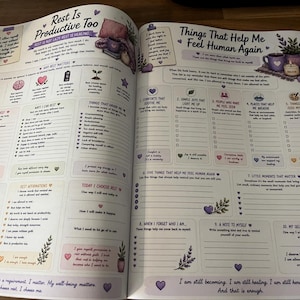 May include: An open self-care journal with two pages featuring purple-themed illustrations, checklists, and prompts. The left page is titled Rest Is Productive Too, and the right page is titled Things That Help Me Feel Human Again, both containing text.