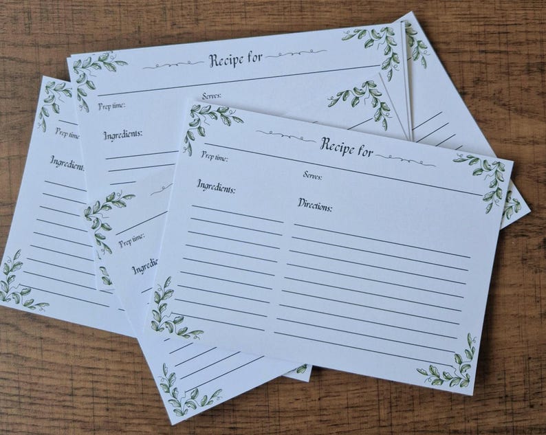 May include: Several white recipe cards with spaces for ingredients and directions. Each card features a green floral corner design and the words "Recipe for" at the top. The cards are stacked.